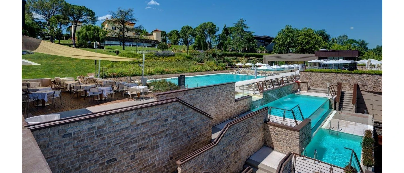 Swimming pools cascaded over mutliple levels, set in stone walled terraces and overlooked by landscaped gardens