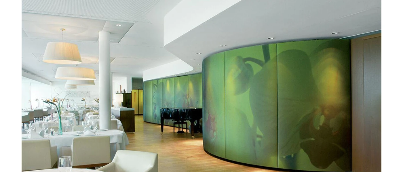 Restaurant with crisp white tablecloths, a black piano in the corner and a beautiful green floral wall mural to one side