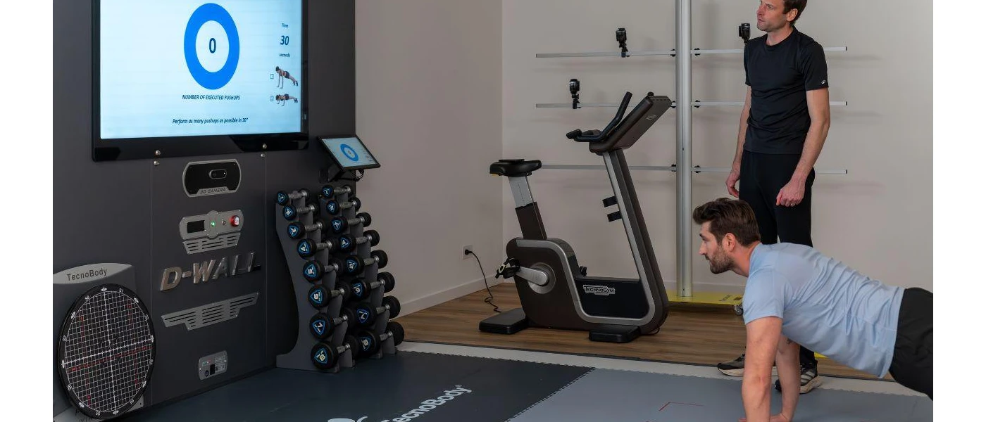 A male guests is having an analysis done with the health coach while doing a push up 