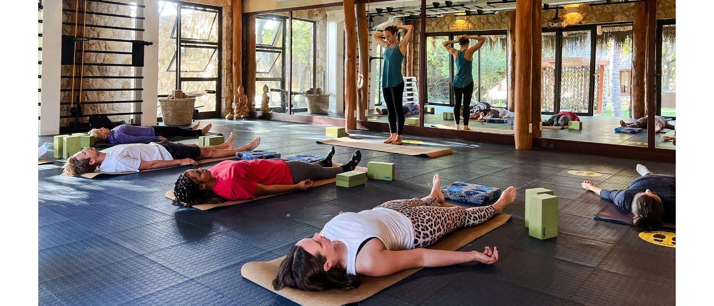 Group of people lying down on yoga mats in a fitness studio