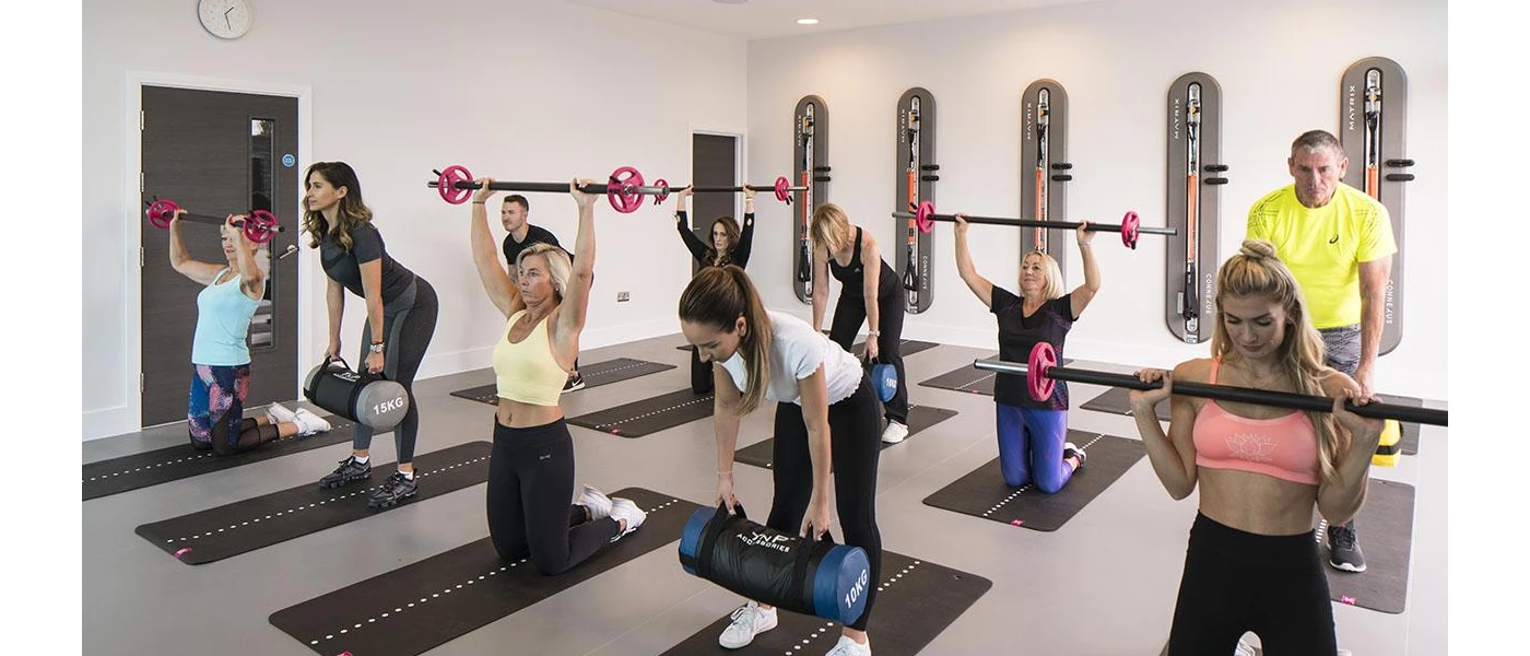 Group participating in a fitness class using weighted barbells