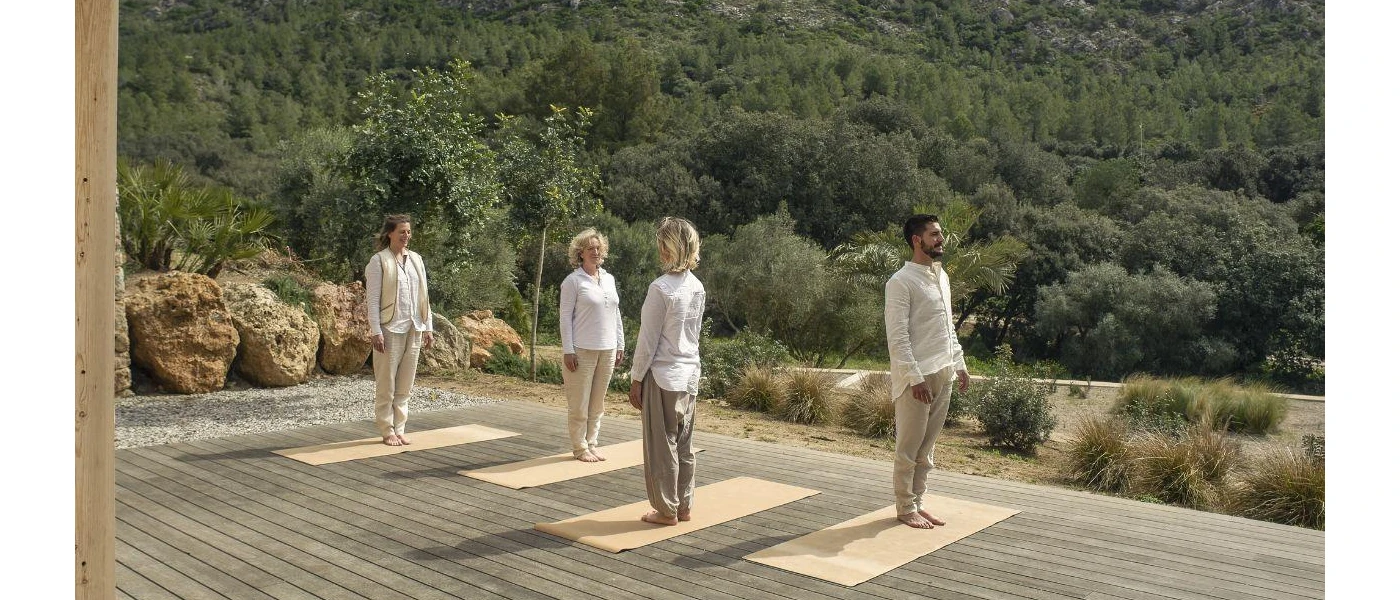Group of people in a deck participating in a class overlooking lush greenery
