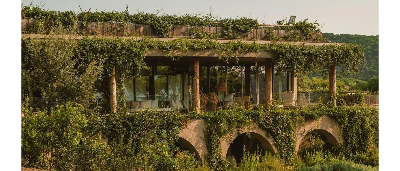 Building cloaked in greenery under a blue sky