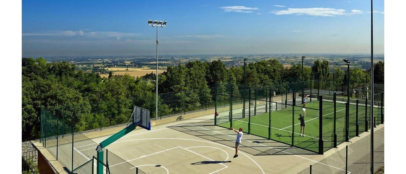 People in active wear enjoying the tennis and basketballs courts, next to the countryside