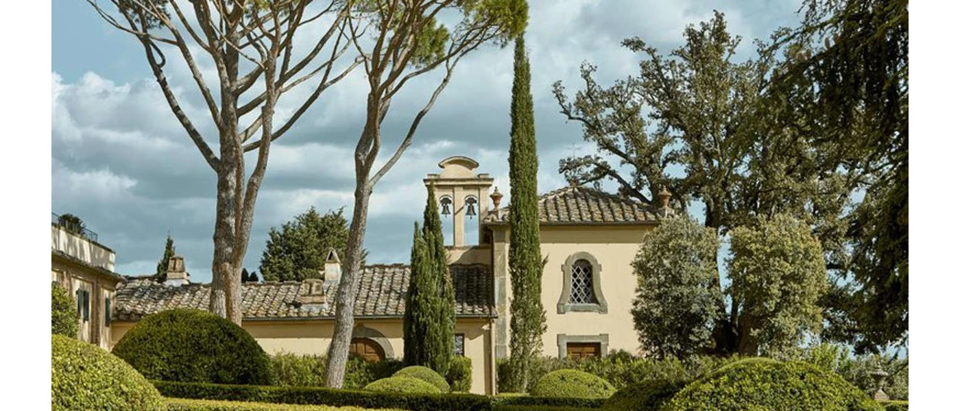 Traditional Tuscan building with a bell tower, tiled roof and surrounding greenery