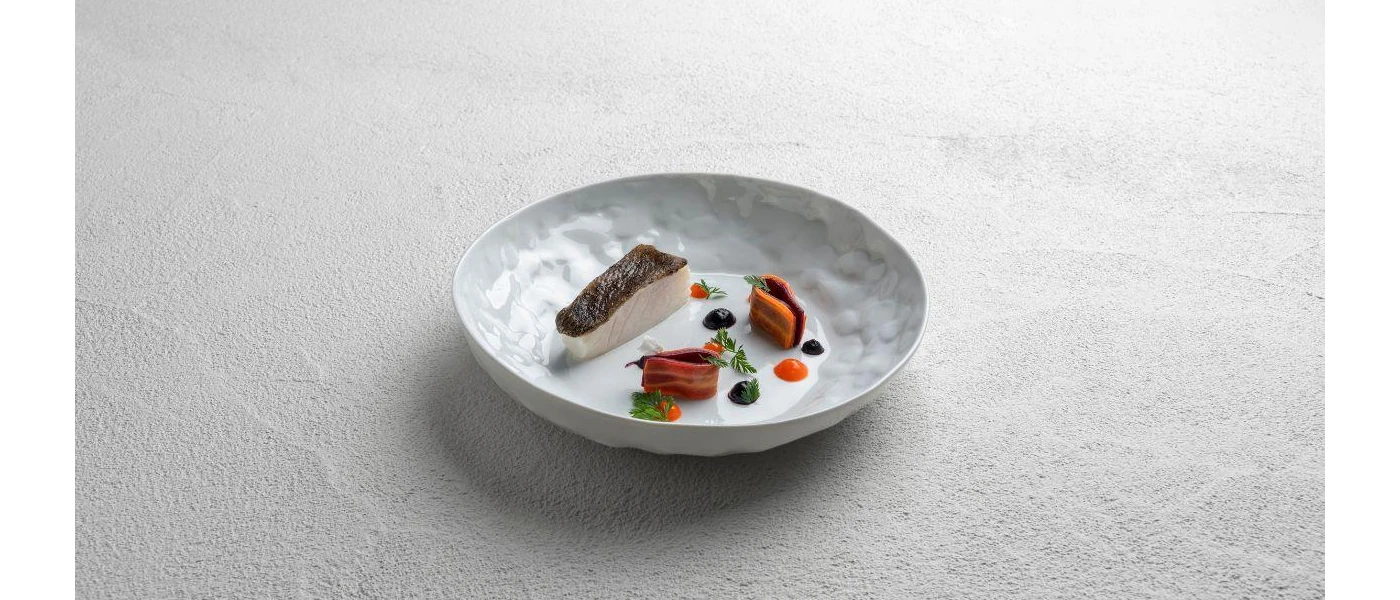 Small portions of seafood and meat on a white plate