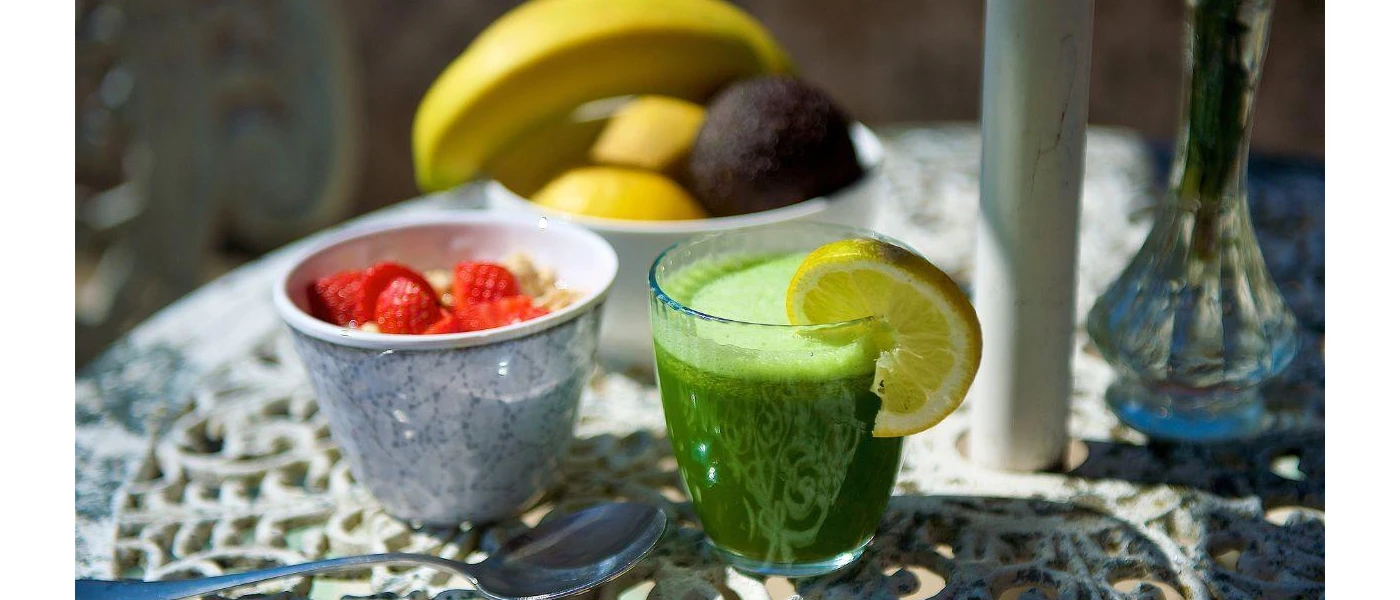 Fruit bowl, pot of yoghurt and strawberries and a green smoothie