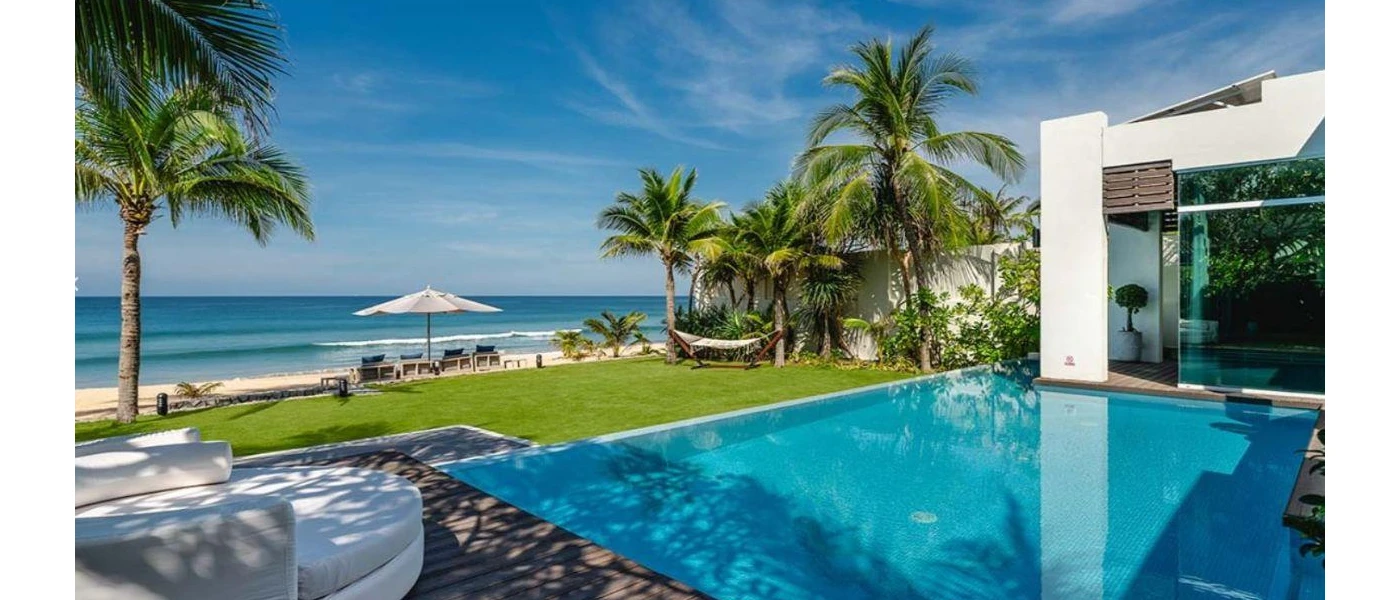 Beachfront pool in a wooden terrace in front of a lawn, overlooking the Andaman Sea