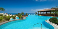 Sunlit pool at Hacienda del Conde, Tenerife, surrounded by loungers and palm trees