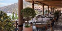 Taverna at Daios Cove Smart looking restaurant with outdoor seating overlooking the beach and mountain