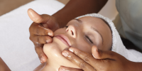 Woman receiving a relaxing facial treatment at Body Holiday spa.