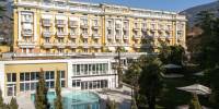 Landscaped gardens, a swimming pool surrounded by palms, and the exterior of Palace Merano