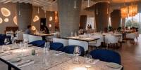 Stylish restaurants at Palmaïa – The House of AïA Modern restaurant with blue and grey chairs, marble-like tables, and macrame light lanterns