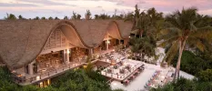 Thatched, curved roof restaurant, with multiple terraces including those right on the beach