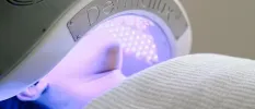 Person under a facial machine omitting light