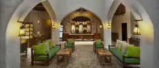 Hotel area with lime green sofas, stone floors, vaulted ceiling and atmospheric lighting