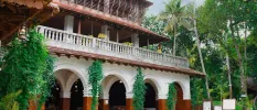 Traditional Indian architecture - sweeping archways, white balustrades, terracotta and white stone pillars and a terracotta tiled rooftop