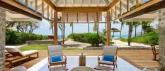 Chairs and coffee table and a lounger in a terrace overlooking the beach