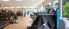 Gym with full-length windows, treadmills, a rowing machine, exercise balls and weights machines