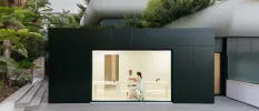 Futuristic looking wellness consultation room with a square black exterior and gleaming white interior
