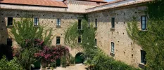Stone-walled palazzo with climbing greenery and terracotta-tiled rooftops
