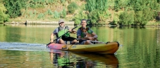 Two men in a kayak with a dog