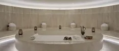 Wellness room dressed with marble, with a pouring jug and white towels 