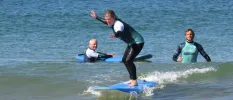 Group in wet suits surf in the sea