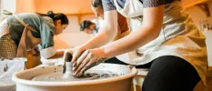 Group in aprons in a pottery class