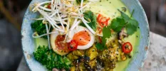 Healthy bowl with egg, broccoli, beansprouts and coriander in a creamy green sauce
