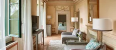 Grand hallway with intricate frescoes, grey armchairs and blue cushions