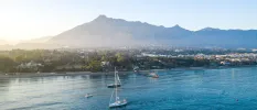 Spanish coastline with mountains in the background and boats bobbing in the sea