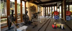 Gym with floor-to-ceiling windows equipped with a bike, rower and weightss
