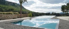 Outdoor swimming pool with an infinity edge and a view of the surrounding countryside