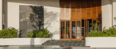 SHA Wellness Clinic entrance, with large wood-panelled doors, stone steps and palm shrubs either side
