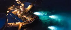Cliffside restaurant with an al fresco dining terrace and in-water lights showcasing the rocks in the sea below