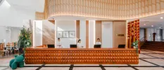 Airy reception with a wooden desk, white walls and ceilings and staff members in white uniforms