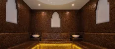 Dark tiled steam bath with Arabic-style archways