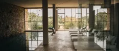 Indoor swimming pool and loungers with floor-to-ceiling windows overlooking the countryside