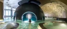 Indoor pool with a cave-like centre, domed ceiling and surrounding whirlpool sections