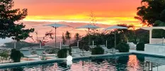 Swimming pool with loungers at sunset 