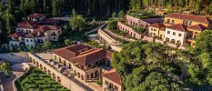 Terracotta-roofed resort on a leafy hillside surrounded by a pine forest