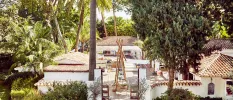 Central hotel courtyard with surrounding greenery, whitewashed buildings and terracotta rooftops