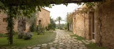 Cobbled courtyard surrounded by traditional farmhouse buildings and greenery