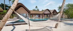 Thatched-roof villas overlooking white sands, and a hammock strung between two palm trees