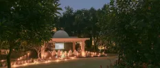 Domed pavilion at twilight, with a cinema screen, white bean bag chairs and candlelight