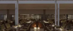Lantern-lit restaurant with white pillars, dark-wood tables and chairs and full-length windows