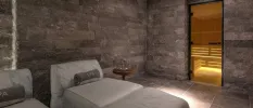 Marble relaxation area with plush cushioned buds and the entrance to a softly lit wooden sauna