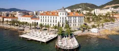 Hotel exterior with white walls and terracotta rooftops overlooking the sea