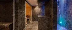 Spa with grey marble walls, blue LED lighting, a sauna and tiled steam room